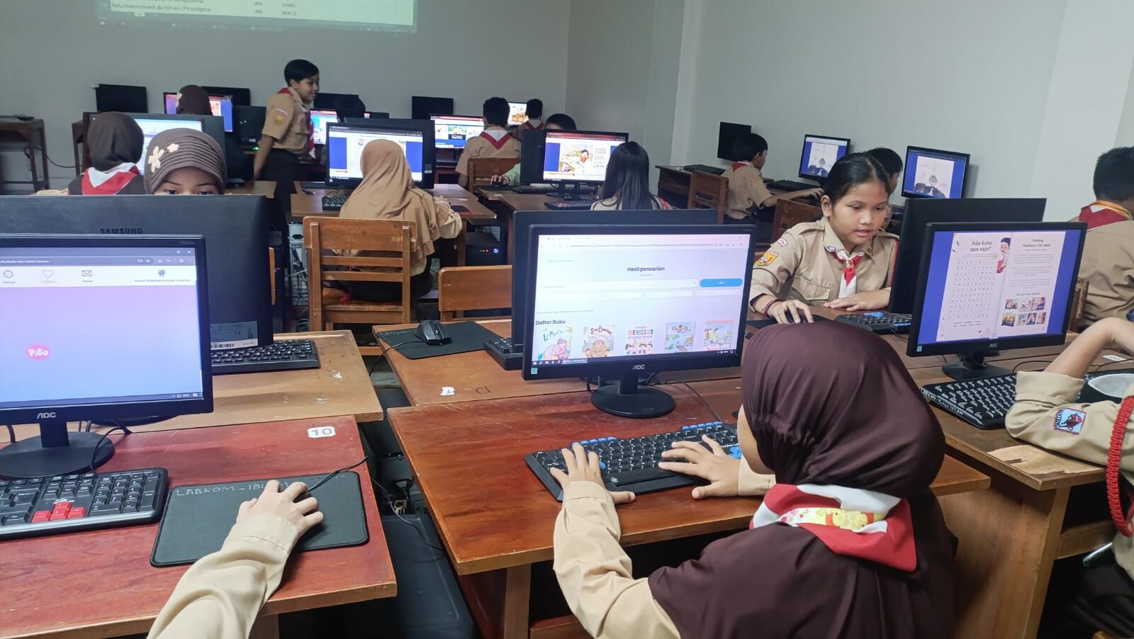 Siswa membaca dan mengerjakan tugas PiBo di lab komputer sekolah
